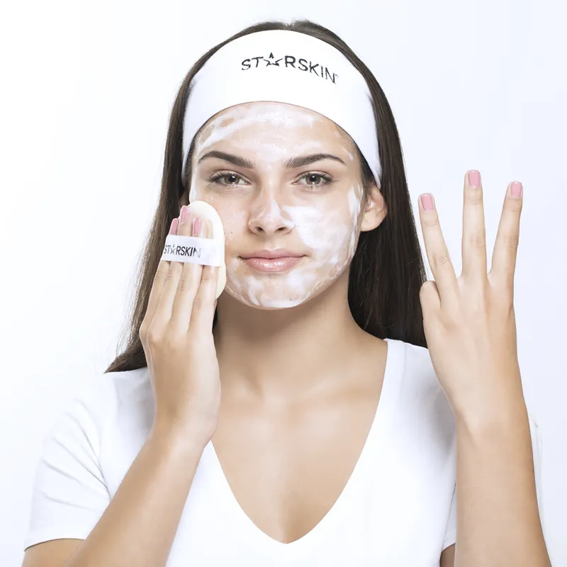 Frau trägt eine Gesichtsmaske und ein Stirnband mit der Aufschrift 'STARSKIN'.