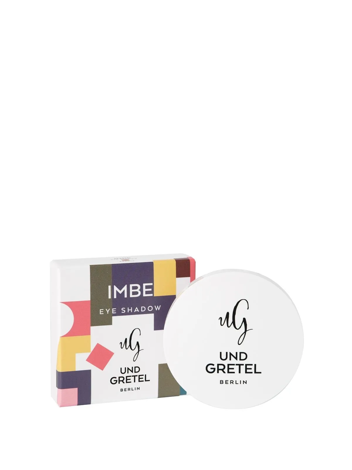 Und Gretel IMBE Lidschatten in weißer Verpackung mit bunter Schachtel im Hintergrund.