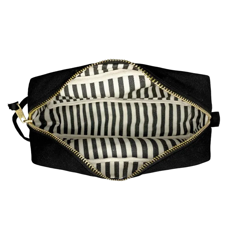 Schwarze Kosmetiktasche mit goldfarbenem Reißverschluss und schwarz-weiß gestreiftem Innenfutter.