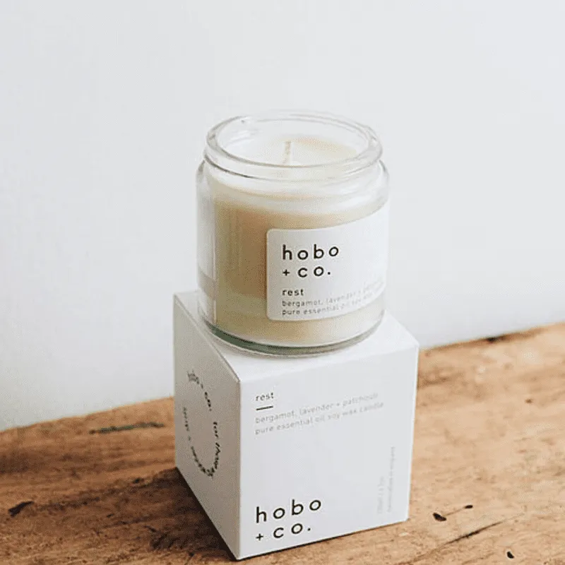Hobo+Co Rest Duftkerze mit ätherischen Ölen, 120ml, auf Holztisch vor weißer Wand.