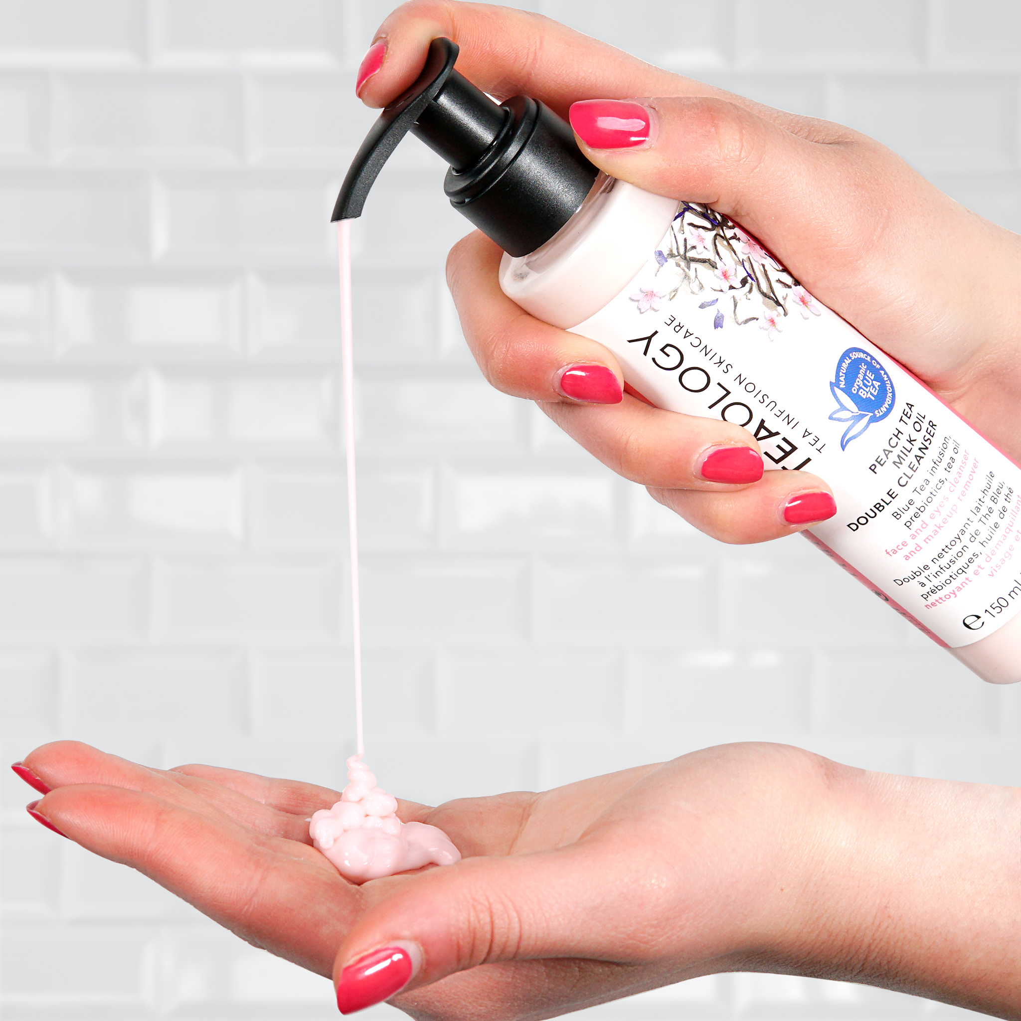 Eine Hand drückt den Inhalt eines Flaschenreinigers auf die andere Hand vor einem weißen Hintergrund.