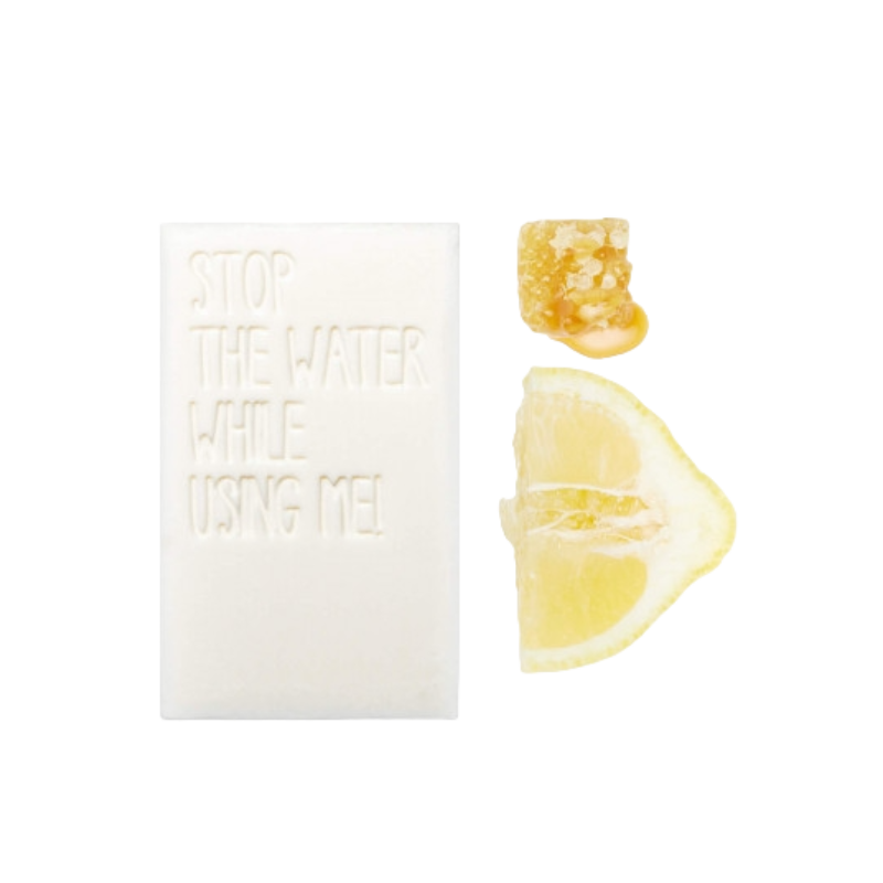 STOP-THE-WATER-WHILE-USING-ME-ALL-NATURAL-LEMON-HONEY-BAR-SOAP STOP THE WATER WHILE USING ME! All Natural Lemon Honey Bar Soap neben Zitronenscheibe und Honigstück.