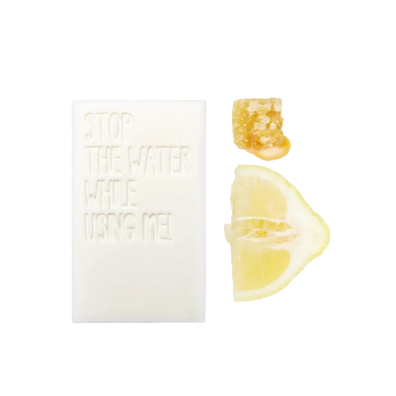 STOP THE WATER WHILE USING ME! All Natural Lemon Honey Bar Soap neben Zitronenscheibe und Honigstück.
