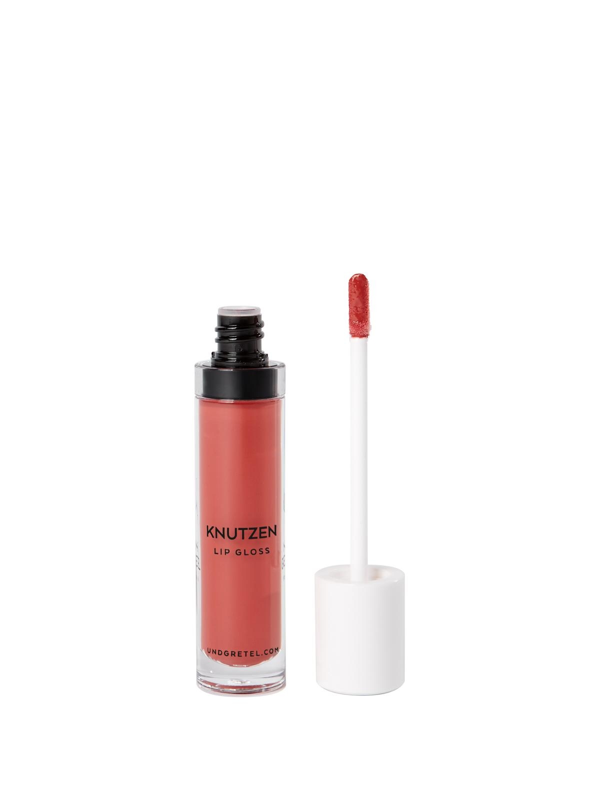 Roter Lipgloss in einer durchsichtigen Tube mit schwarzem Deckel und Applikator daneben.
