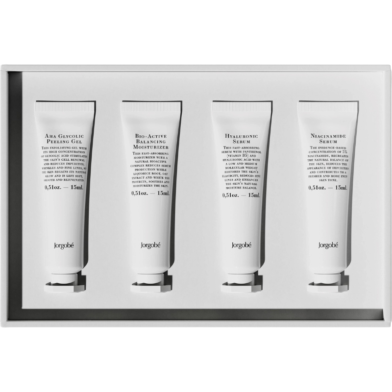 Vier Tuben Hautpflegeprodukte in einer weißen Box, beschriftet als Peeling-Gel, Feuchtigkeitscreme, Hyaluronsäure-Serum und Niacinamid-Serum.
