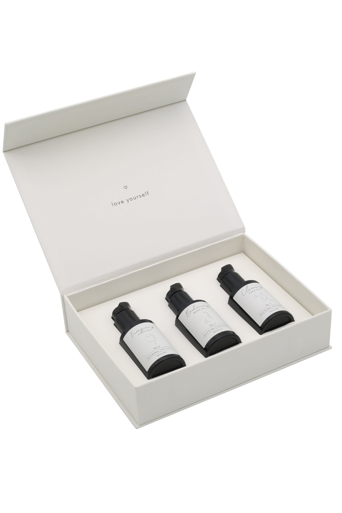hs-015_facebodyminicollection_freisteller_2 Offene weiße Box mit drei schwarzen Flaschen, beschriftet mit 'love yourself'.