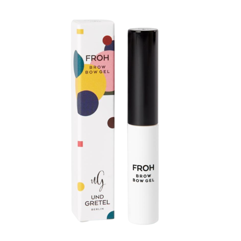 UND-GRETEL-FROH-BROW-BOW-GEL-1-NATURAL UND GRETEL FROH Brow Bow Gel 1 Natural, weiße Tube mit schwarzem Deckel, bunte Verpackung im Hintergrund.