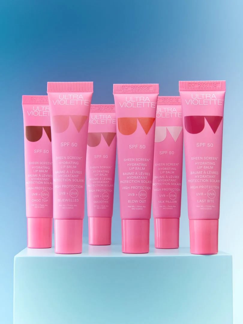 SheenScreeneCommImagery Fünf rosa Tuben Ultra Violette Sheen Screen SPF 50 Lippenbalsam auf blauem Hintergrund.