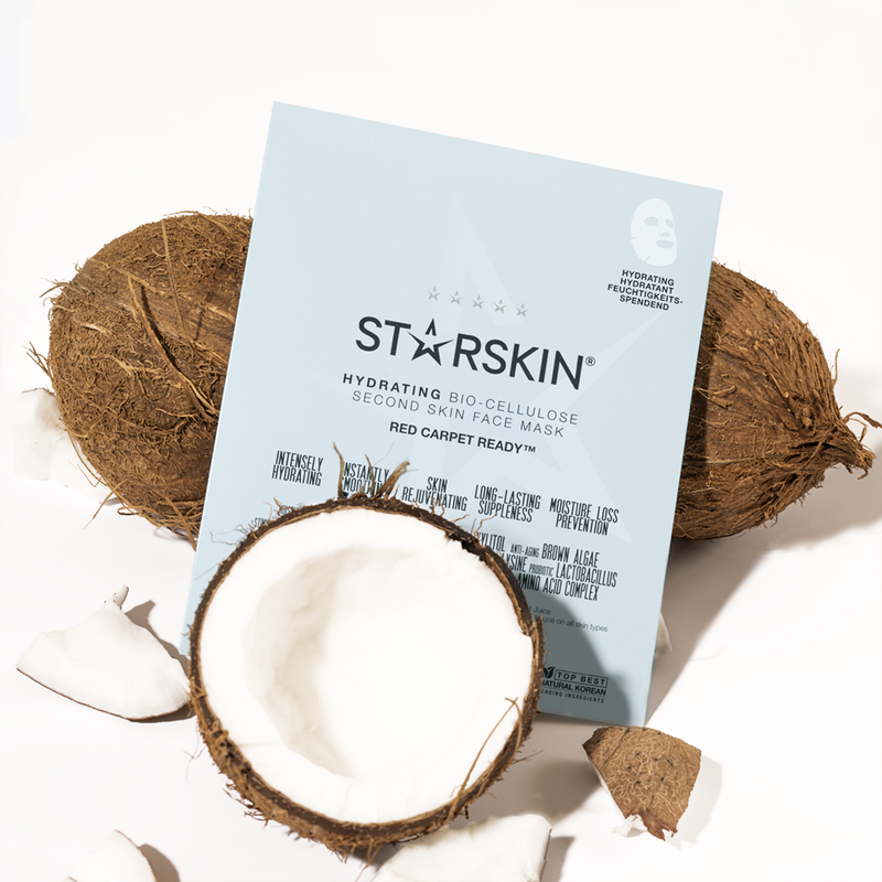 STARSkin Red Carpet Ready Gesichtsmaske vor aufgebrochenen Kokosnüssen auf weißem Hintergrund.