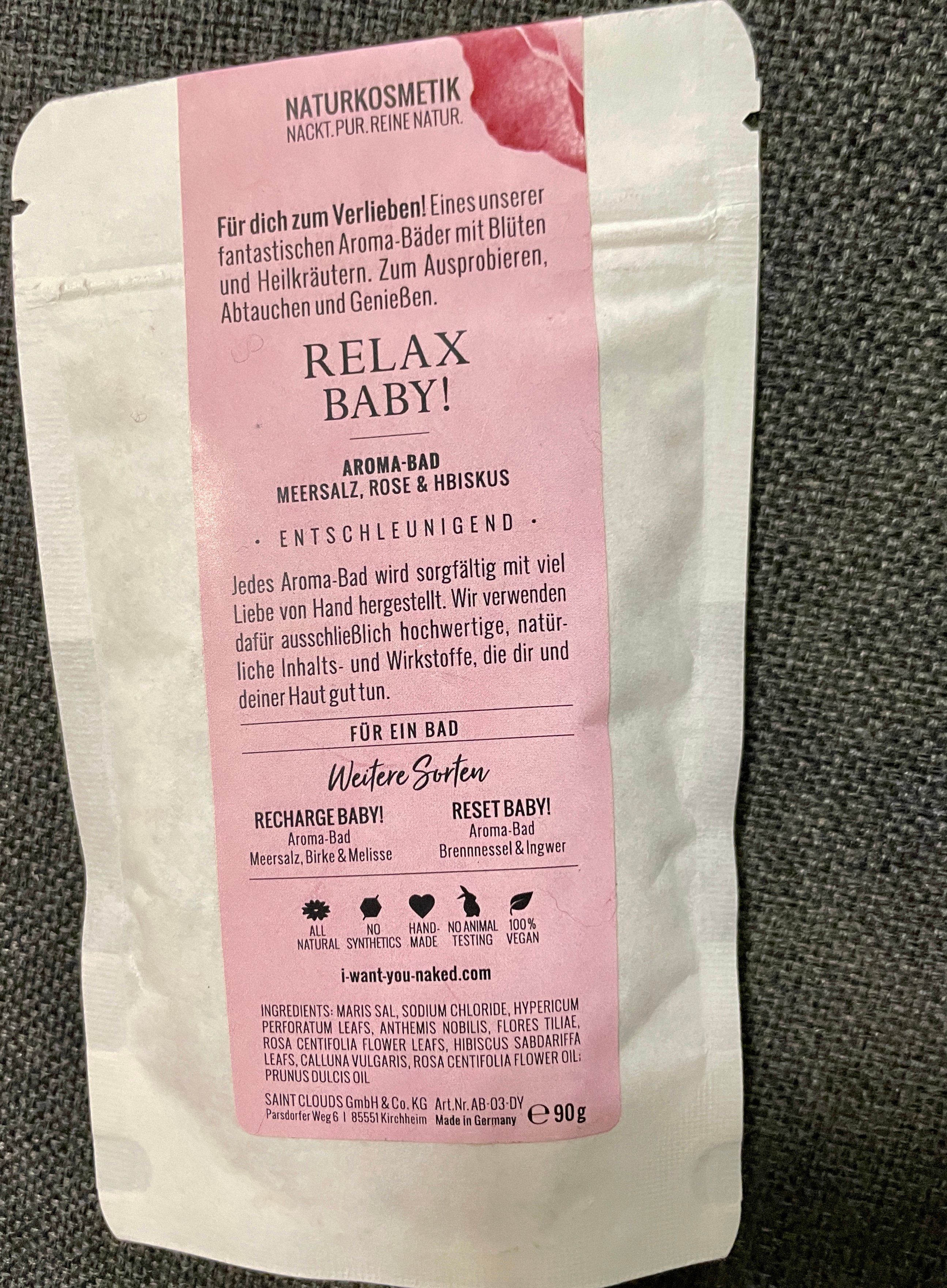 Verpackung eines Aroma-Bads mit Meersalz, Rose und Hibiskus, Produktname 'Relax Baby!' und Beschreibung auf Deutsch.