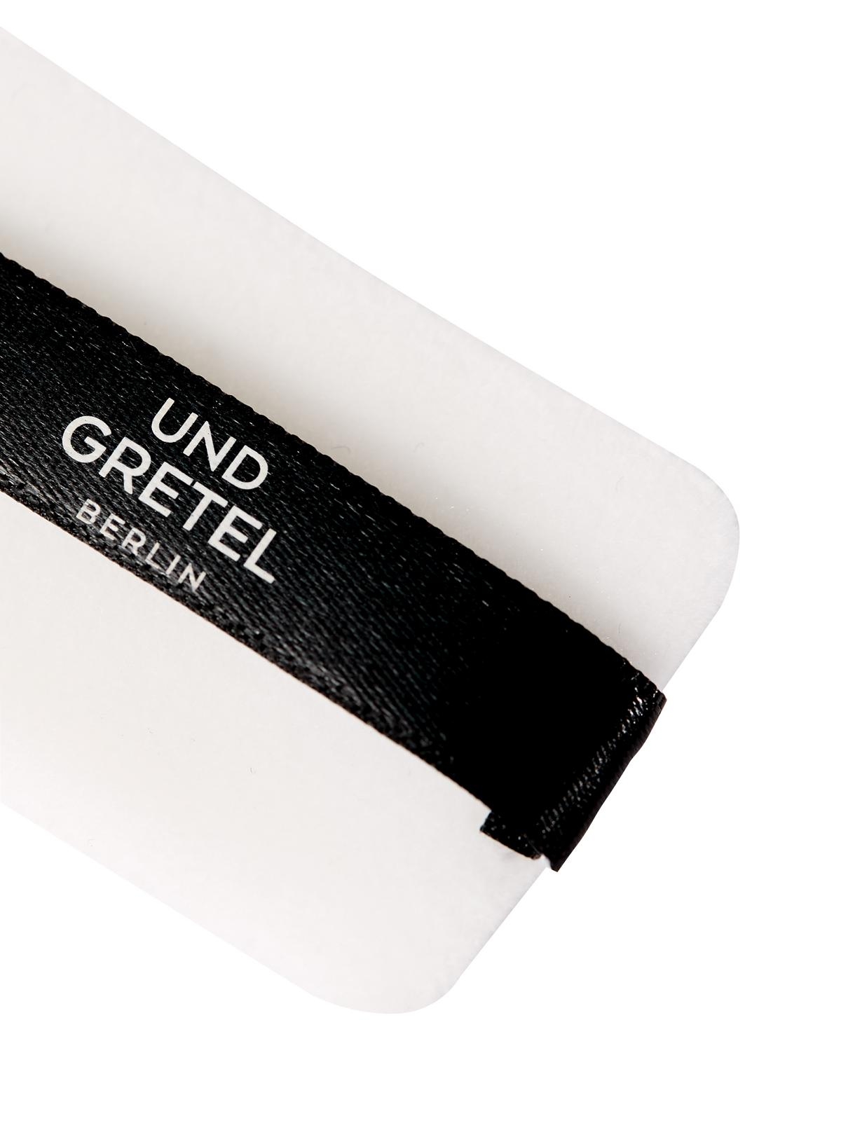 Schwarzes Band mit der Aufschrift 'UND GRETEL BERLIN' auf weißem Hintergrund.