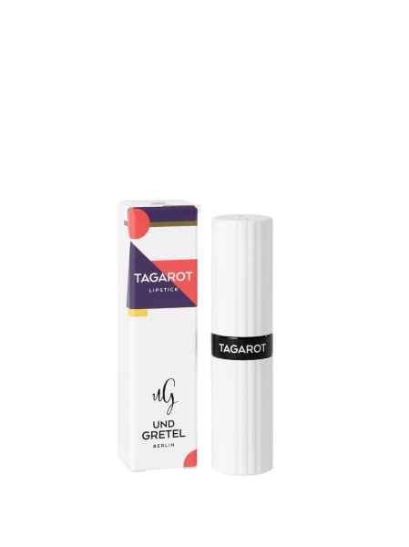 TAGAROT Lippenstift von Und Gretel Berlin, weiße Verpackung mit schwarzem Band und bunter Schachtel im Hintergrund.